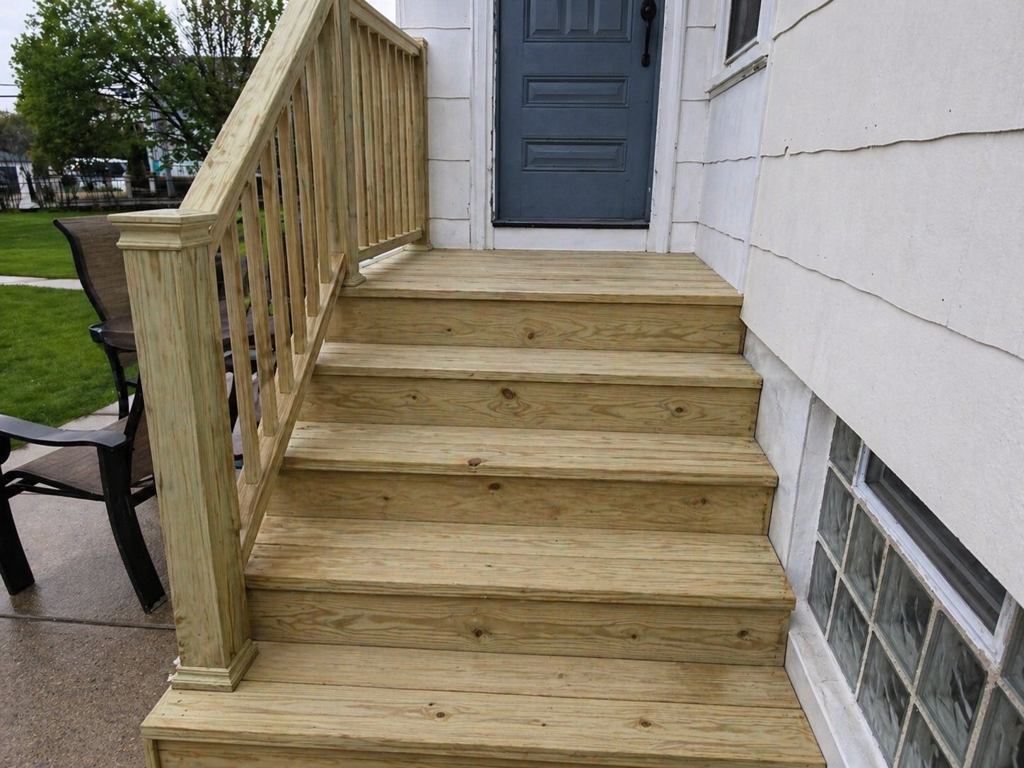 Porch stairs rebuilt in bare unpainted lumber during restoration