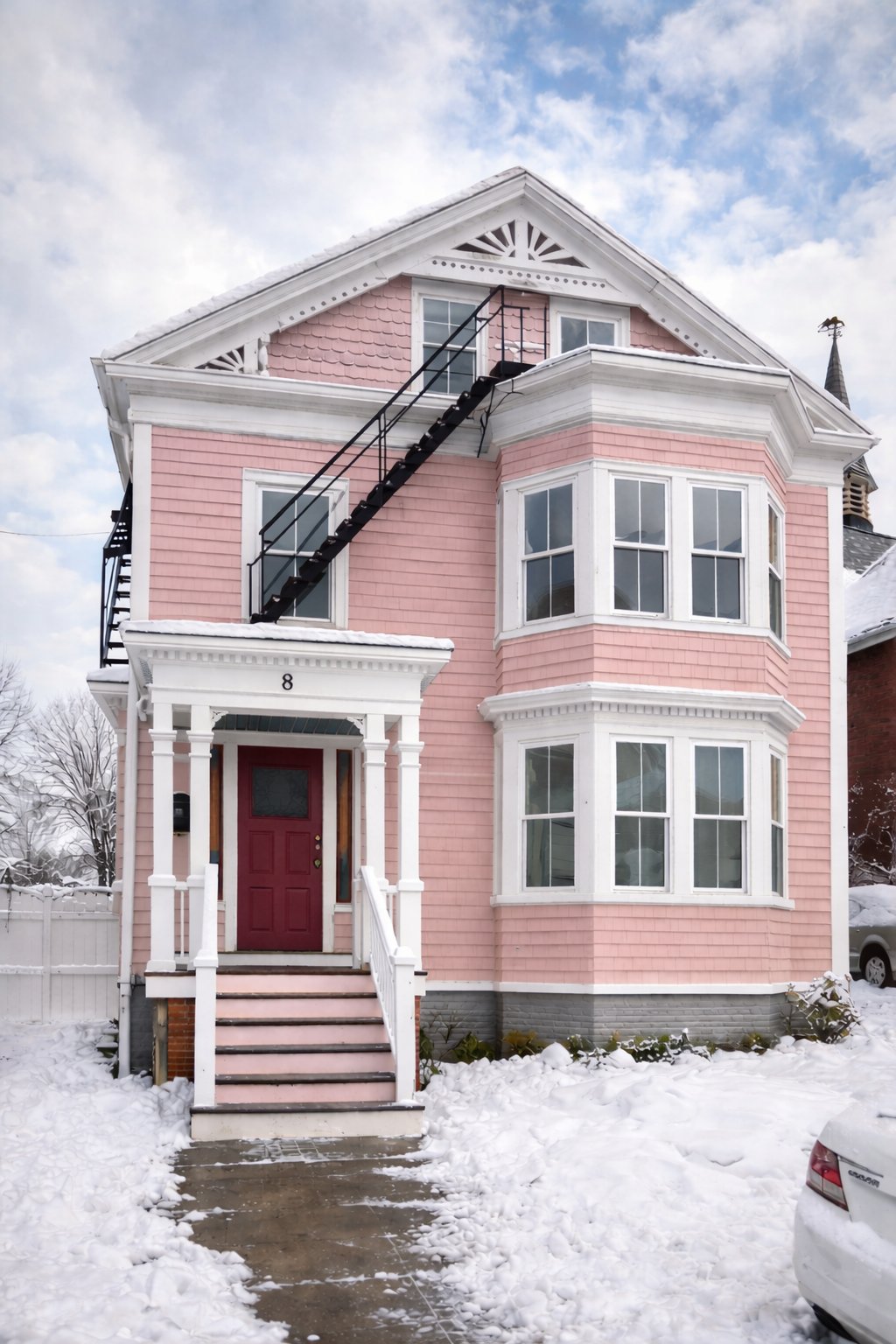 Victorian house exterior freshly painted pink with white trim